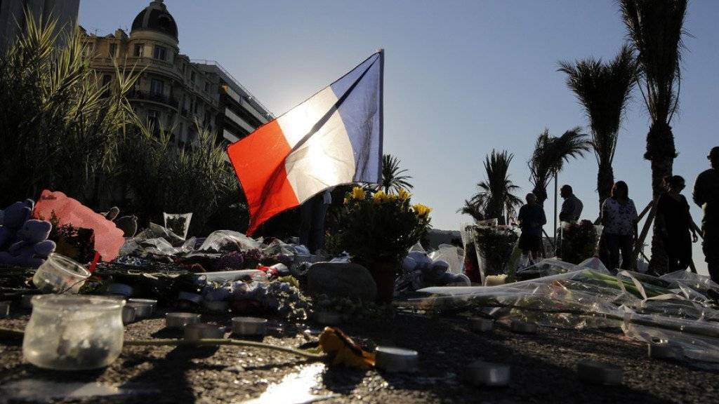 Gedenken an die Opfer des Terrorattentates von Nizza: Eine französische Flagge und Blumen am Boden des Boulevard des Anglais.