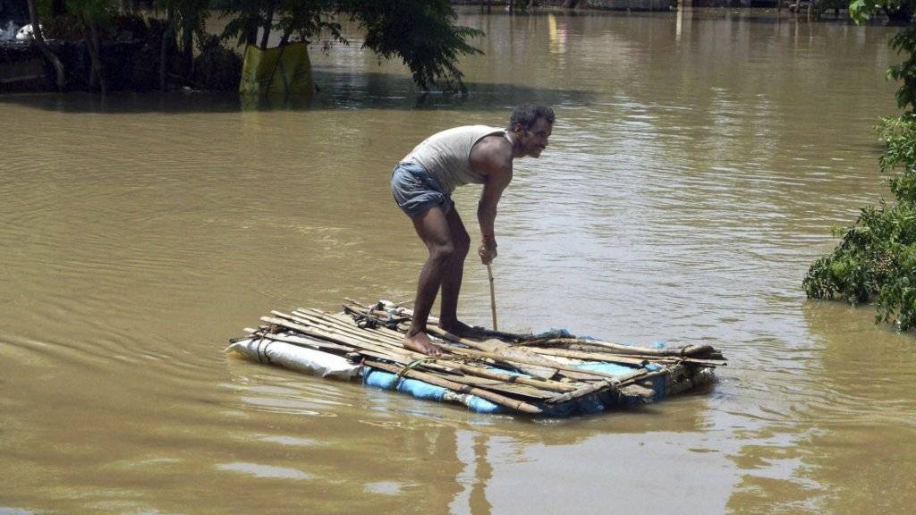 Dieser Mann weiss sich selbst zu helfen; ein ranghoher Politiker liess sich bei einem Besuch in den indischen Überschwemmungsgebieten dagegen von Polizisten tragen.