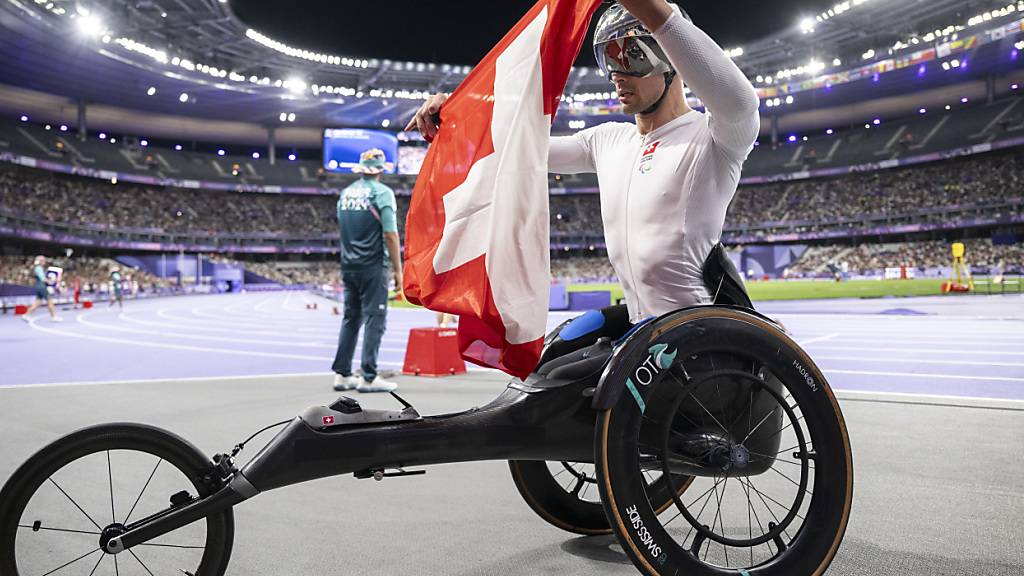 Ein gewohntes Bild: Marcel Hug nimmt die Schweizer Flagge entgegen