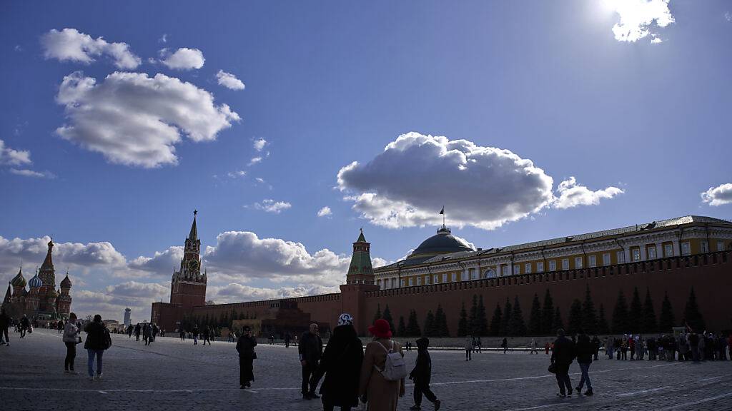 Menschen spazieren über den Roten Platz mit dem Kreml im Hintergrund in Moskau. Foto: Alexander Zemlianichenko/AP/dpa