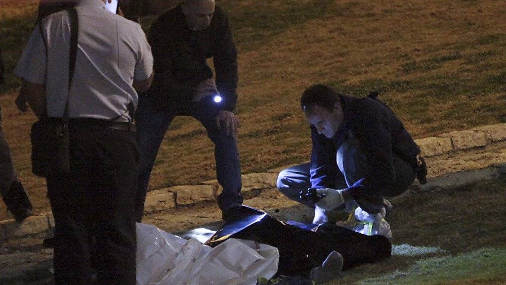 Israelische Polizisten untersuchen die Leiche eines getöteten Palästinensers in Jerusalem.