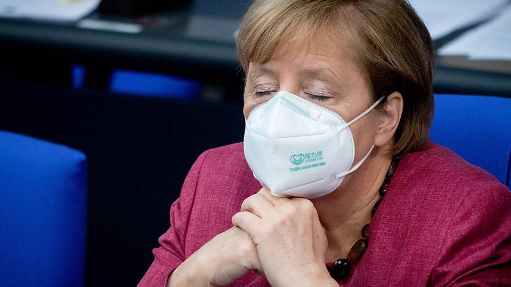 Bundeskanzlerin Angela Merkel (CDU) verfolgt mit geschlossenen Augen und Mund-Nasenbedeckung die Sitzung des Bundestages. Sie hatte vorher eine Regierungserklärung zur Bewältigung der Corona-Pandemie abgegeben. Foto: Kay Nietfeld/dpa