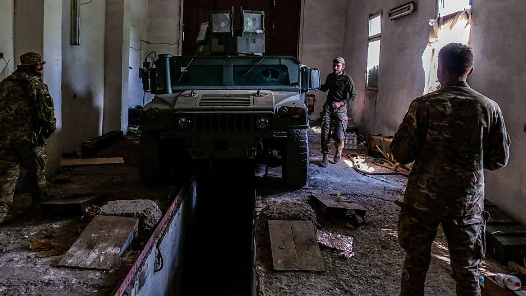 Soldaten bereiten sich mit einem gepanzerten Fahrzeug mit aufmontierten Maschinengewehren auf den Einsatz an der Front vor. Foto: Rick Mave/SOPA Images via ZUMA Press Wire/dpa