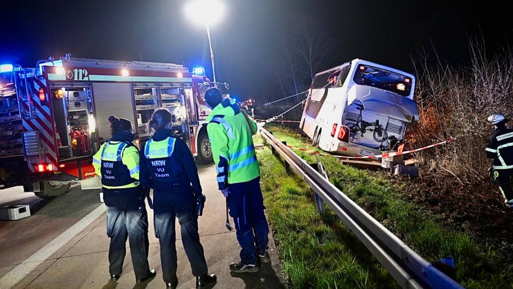 Einsatzkräfte der Feuerwehr und Polizei arbeiten an einer Unfallstelle auf der Autobahn 44 an einem verunfallten Bus. Foto: Daniel Schröder/dpa