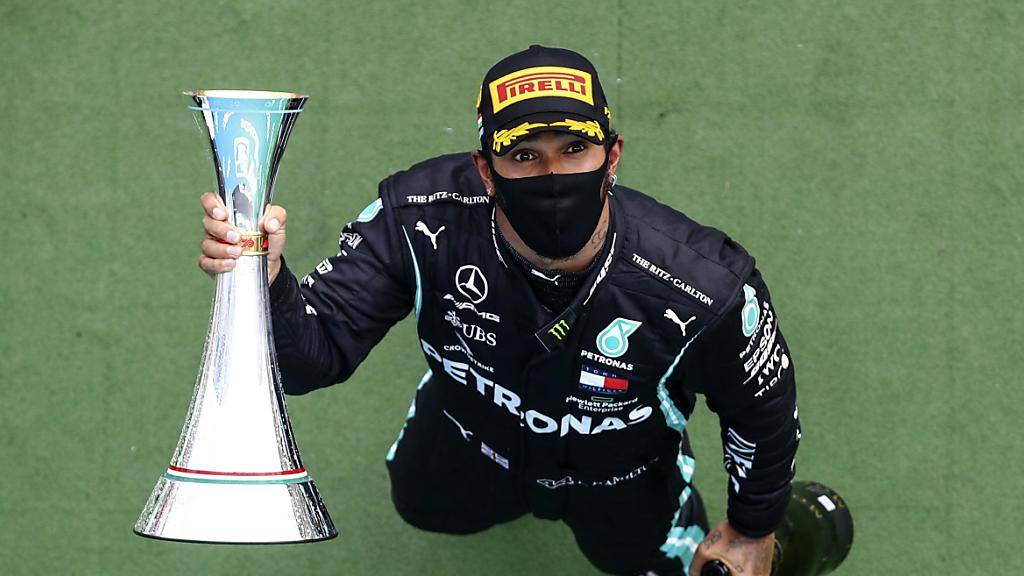 Lewis Hamilton mit Maske, Champagner und Siegertrophäe nach seinem überlegenen Sieg im Grand Prix von Ungarn