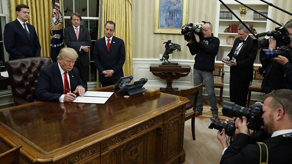 Donald Trump unterschreibt seine erste Exekutivanordnung im Oval Office.