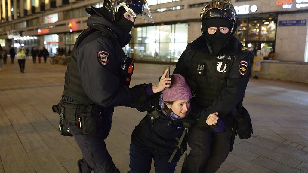 Polizisten nehmen eine Frau fest. Tausende schockierte Russen demonstrierten gegen den Einmarsch ihres Landes in die Ukraine und riefen in den sozialen Medien emotional zu Protesten auf. Foto: Denis Kaminev/AP/dpa