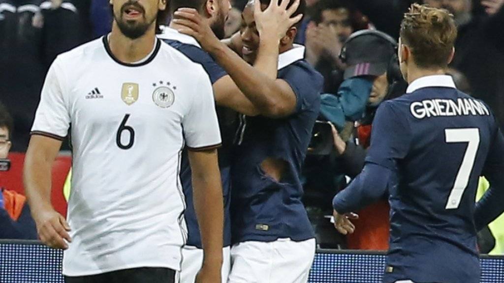 Deutschlands Sami Khedira mit gefasstem Blick, während sich hinten der Franzose Olivier Giroud mit Anthony Martial über den 1:0-Führungstreffer freut