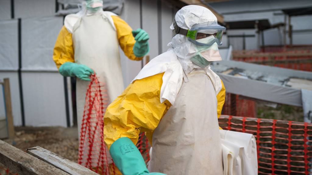 ARCHIV - Helfer kommen in Schutzanzügen zu ihrer Schicht in einem Behandlungszentrum mit Ebola-Erkrankten. Foto: Jerome Delay/AP/dpa