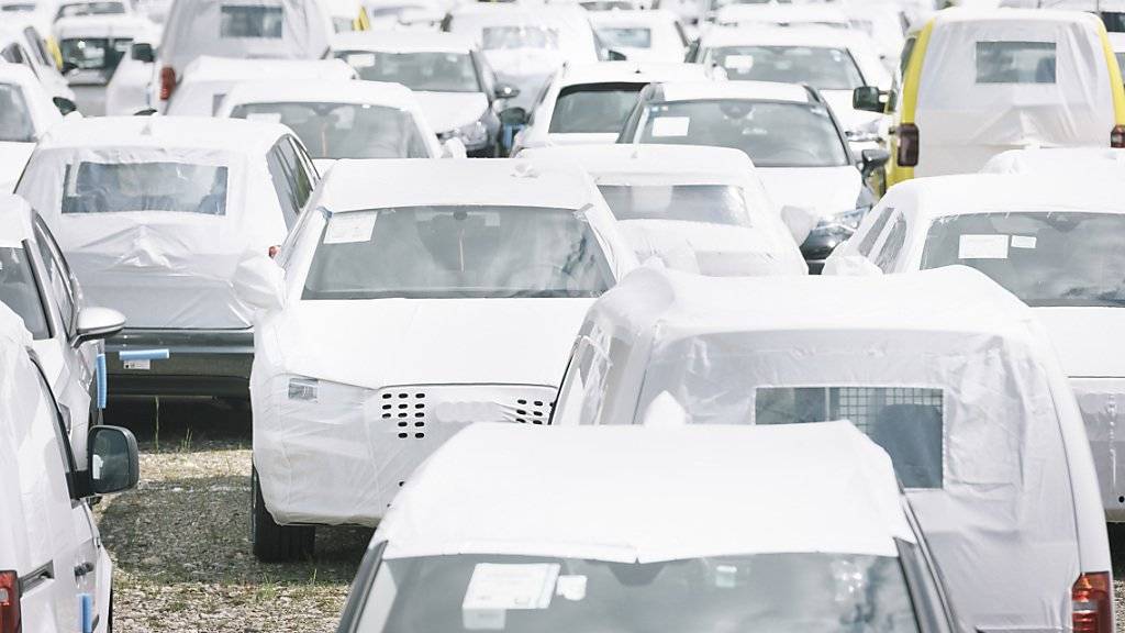 Neuwagen, die zum Schutz mit weisser Plane umhüllt sind, warten auf dem Parkplatz eines Autohändlers auf neue Besitzer. (Archivbild)