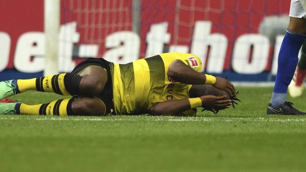 Dortmunds Michy Batshuayi liegt mit schmerzverzerrtem Gesicht am Boden.