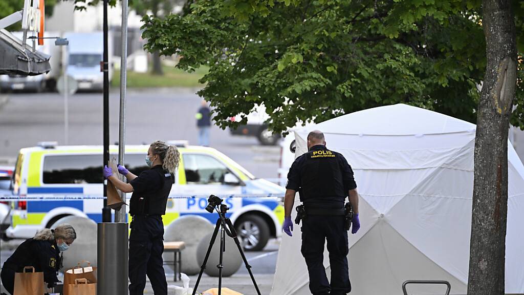 Polizisten sind am Tatort im Einsatz. Bei erneuten Schüssen in einem südlichen Vorort von Stockholm ist ein Mensch getötet worden, drei weitere wurden verletzt. Foto: Anders Wiklund/TT News Agency/AP/dpa