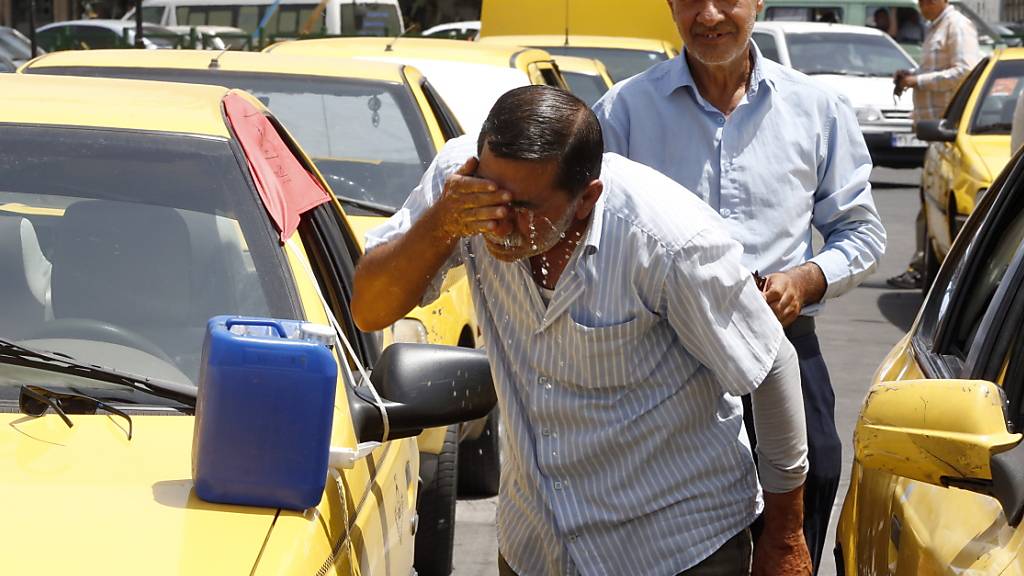 Ein Taxifahrer in der iranischen Hauptstadt Teheran spritzt sich zur Erfrischung Wasser ins Gesicht. (Archivbild)
