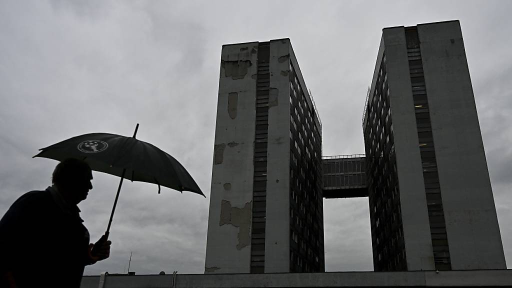 Ein Mann geht mit einem Regenschirm am F. D. Roosevelt Universitätskrankenhaus vorbei, in dem der angeschossene und verletzte slowakische Premierminister Robert Fico behandelt wird. Foto: Denes Erdos/AP/dpa