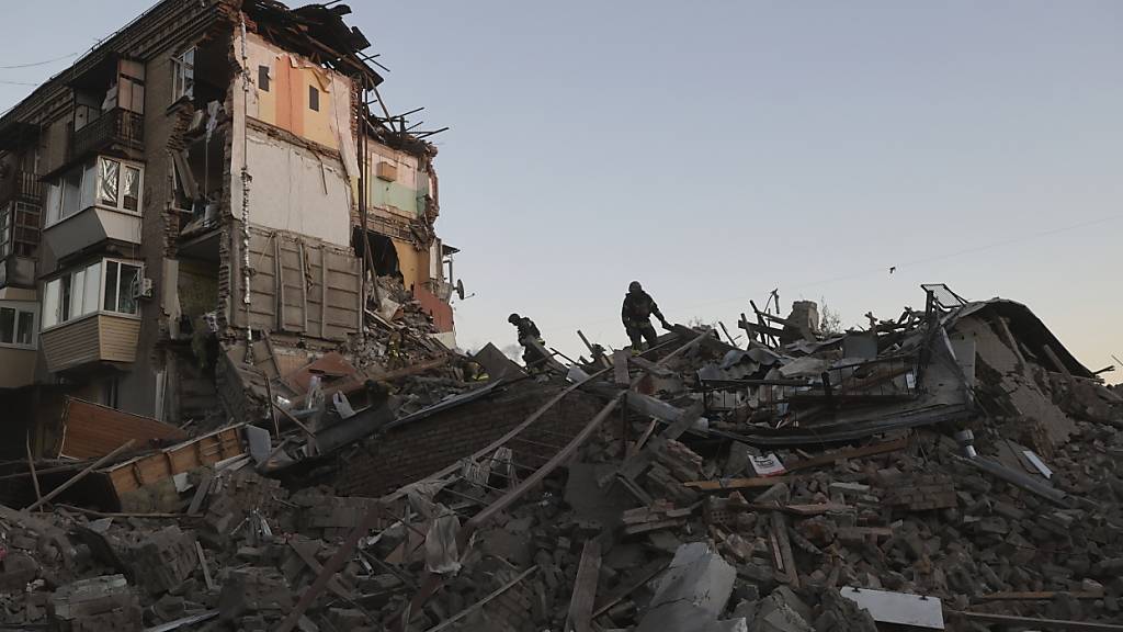 Rettungskräfte räumen die Trümmer eines durch einen russischen Luftangriff zerstörten Wohnhauses weg. Foto: Kateryna Klochko/AP/dpa