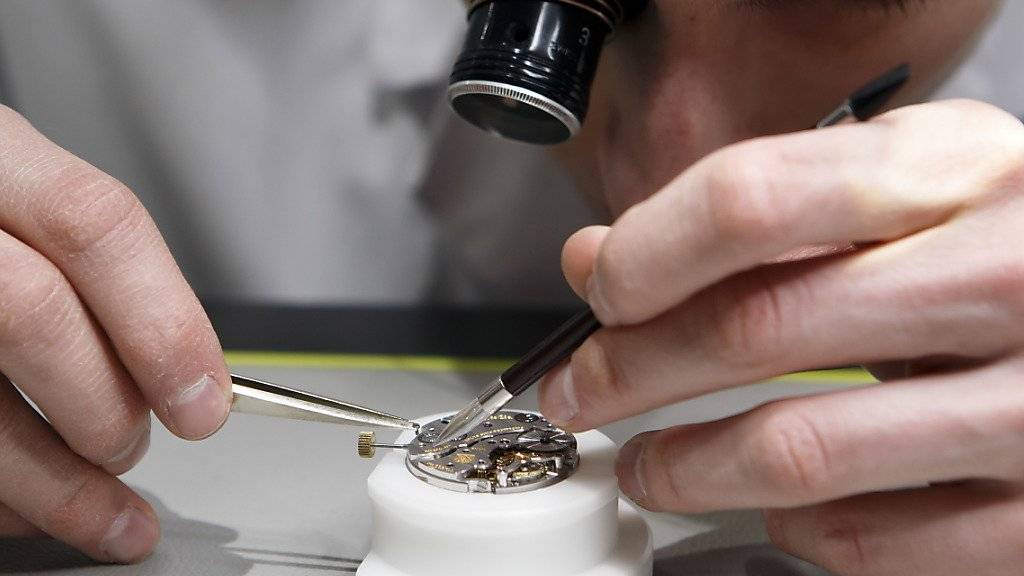 Ein Uhrmacher stellt ein Uhrwerk zusammen. Die Schweizer Uhrenindustrie ist zu Jahresbeginn nicht aus ihrem Tief gekommen. (Symbolbild)