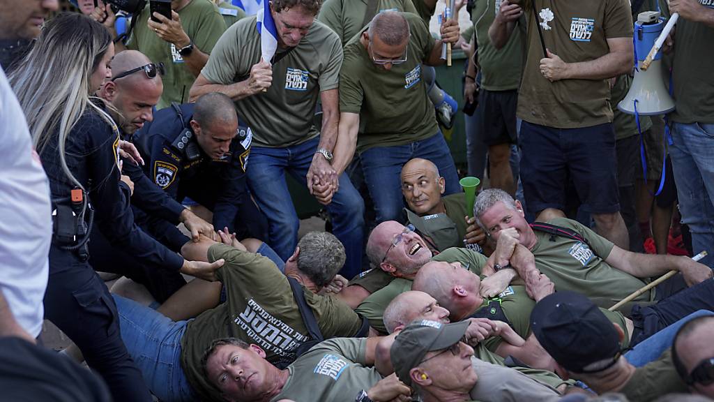 Die israelische Polizei räumt Demonstranten, hauptsächlich Militärreservisten, die eine Straße vor dem Haus von Israels Justizminister Levin blockieren. Foto: Ohad Zwigenberg/AP/dpa