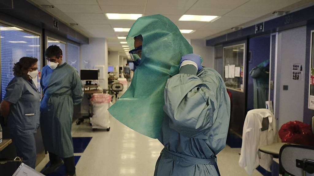 Ein medizinischer Mitarbeiter zieht sich Schutzkleidung auf der Intensivstation der «Clinica Universitaria» an. Foto: Alvaro Barrientos/AP/dpa
