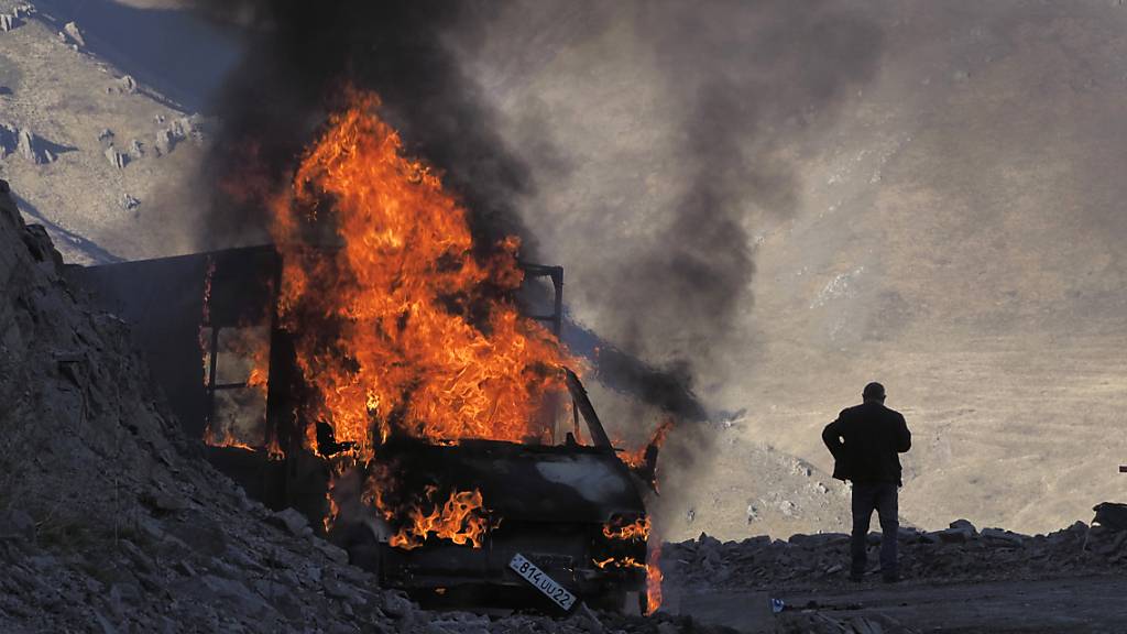 ARCHIV - Ein brennendes Auto nahe der Grenze zwischen Berg-Karabach und Armenien. Foto: ---/AP/dpa