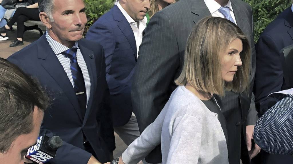 ARCHIV - Lori Loughlin verlässt im August 2019 nach einer Anhörung in dem Hochschul-Bestechungsskandal mit ihrem Ehemann Mossimo Giannulli das Bundesgericht in Boston. Foto: Philip Marcelo/AP/dpa