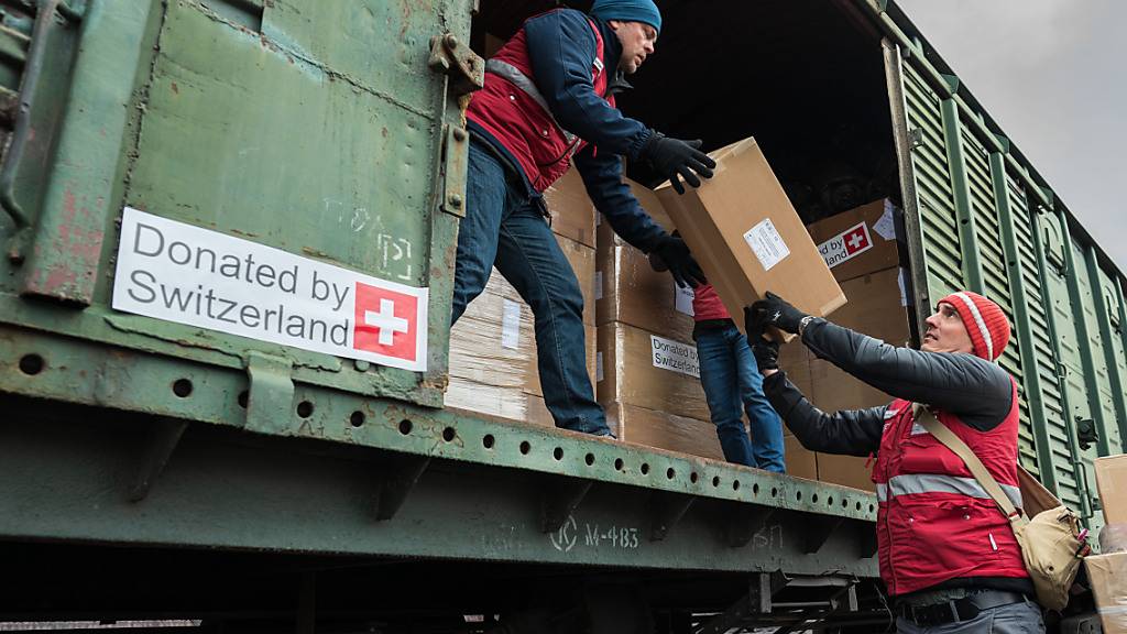 Mitglieder einer Hilfsorganisation helfen beim Beladen eines Zuges mit Schweizer Hilfsgütern. (Archivbild)