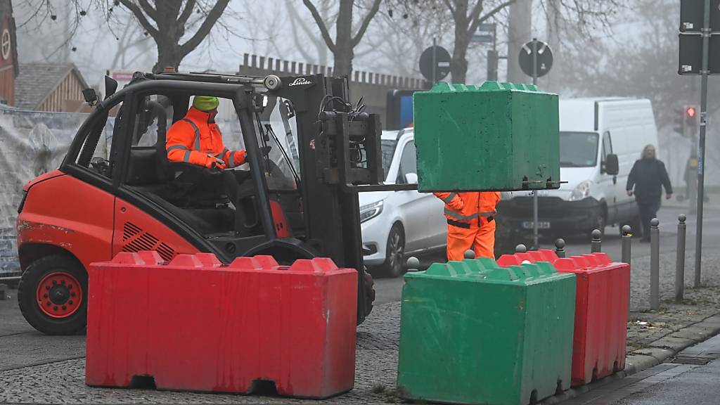 Die Betonblöcke, welche zur Sicherung des Weihnachtsmarktes dienen sollten, werden abgebaut und verladen. Foto: Heiko Rebsch/dpa