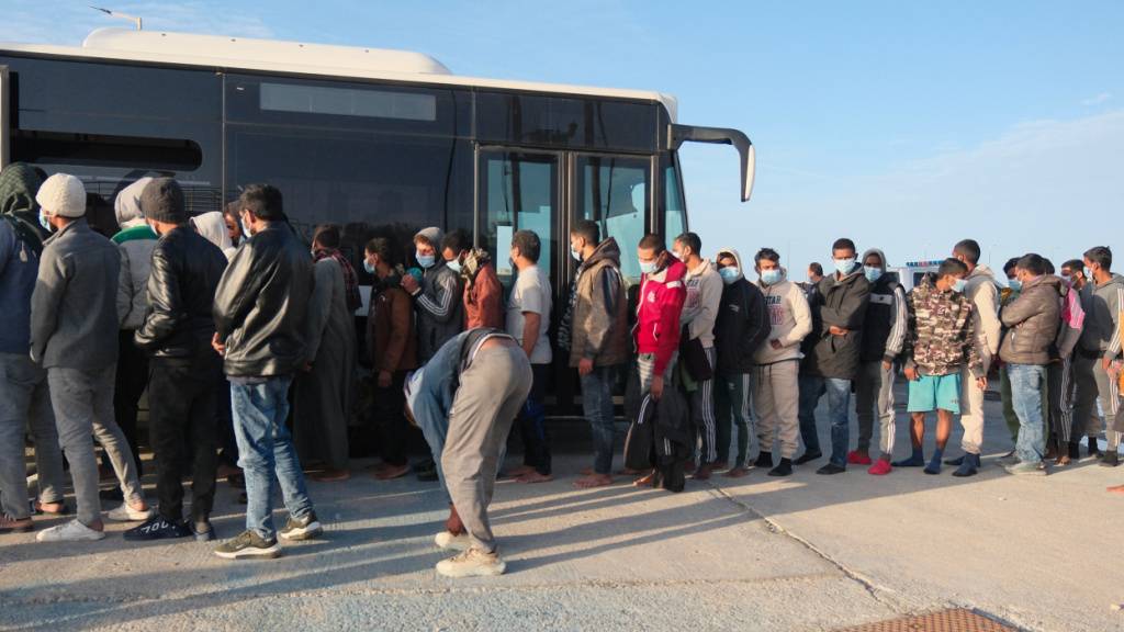 ARCHIV - Migranten gehen nach einer nächtlichen Rettungsaktion der Küstenwache im Hafen von Paliochora auf der Insel Kreta zu einem Bus. (Archivbild) Foto: Giannis Angelakis/AP/dpa