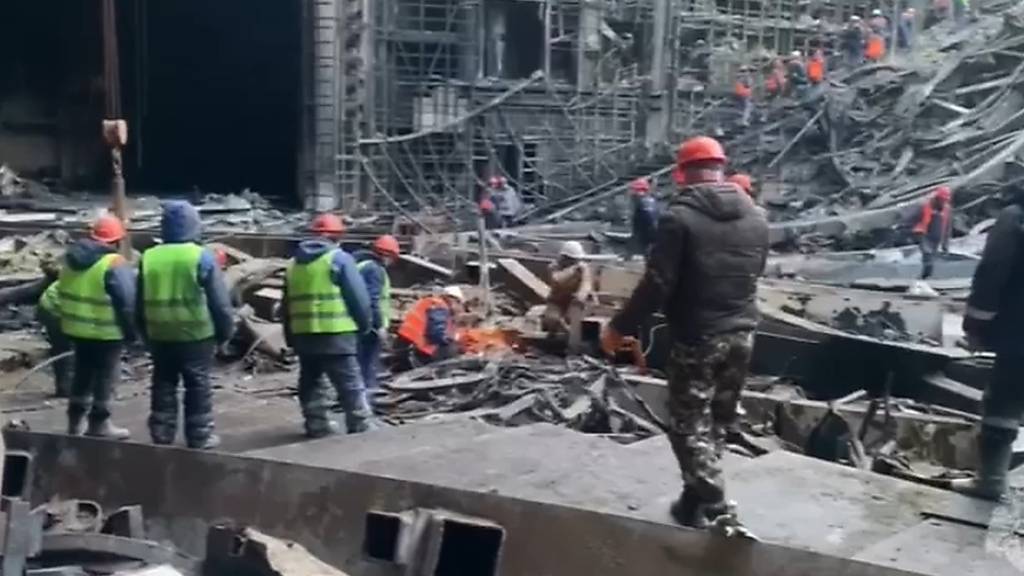 HANDOUT - Auf diesem vom Pressedienst des russischen Katastrophenschutzministeriums veröffentlichten Foto arbeiten Rettungskräfte in der ausgebrannten Konzerthalle nach einem Terroranschlag auf das Gebäude der Crocus City Hall. Foto: Uncredited/Russian Emergency Ministry Press Service/AP/dpa