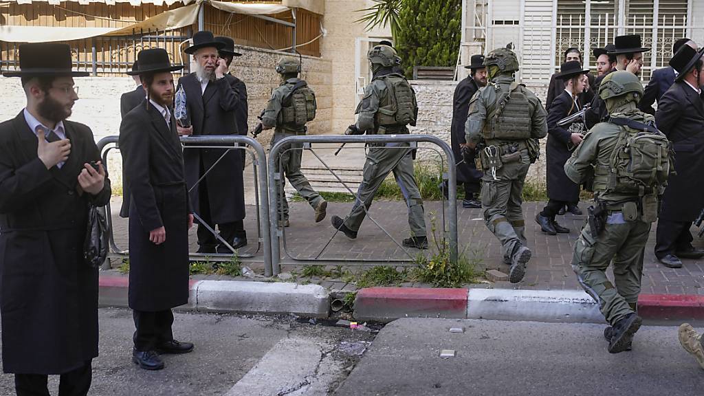 Israelische Sicherheitskräfte verfolgen die mutmaßlichen Angreifer nach einer Auto-Attacke, bei der drei Menschen verletzt wurden. Foto: Ohad Zwigenberg/AP/dpa