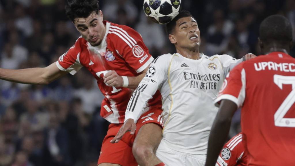 Real Madrids Jude Bellingham (rechts) im Zweikampf mit Bayerns Aleksandar Pavlovic