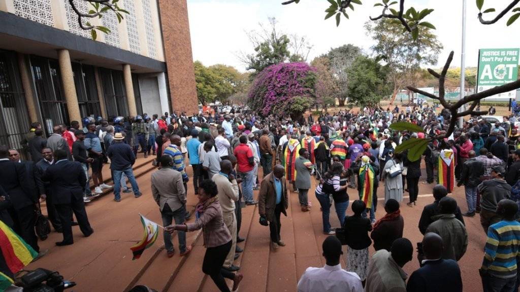 Vor dem Gerichtsgebäude in Harare, in dem der Fall von Evan Mawarire verhandelt wird, versammeln sich Demonstranten.