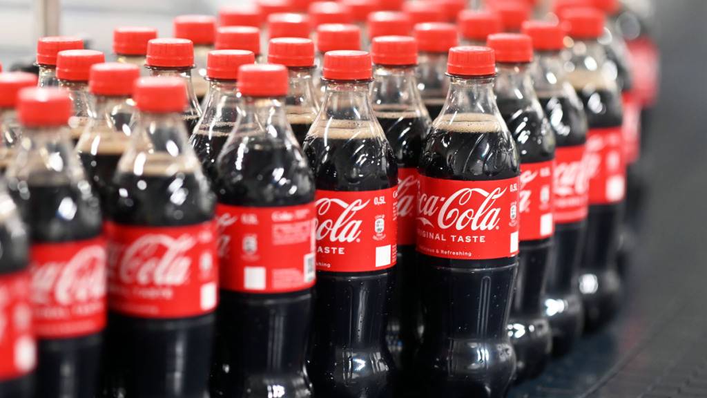 ARCHIV - Coca-Cola-Flaschen laufen über ein Förderband. Foto: Uli Deck/dpa
