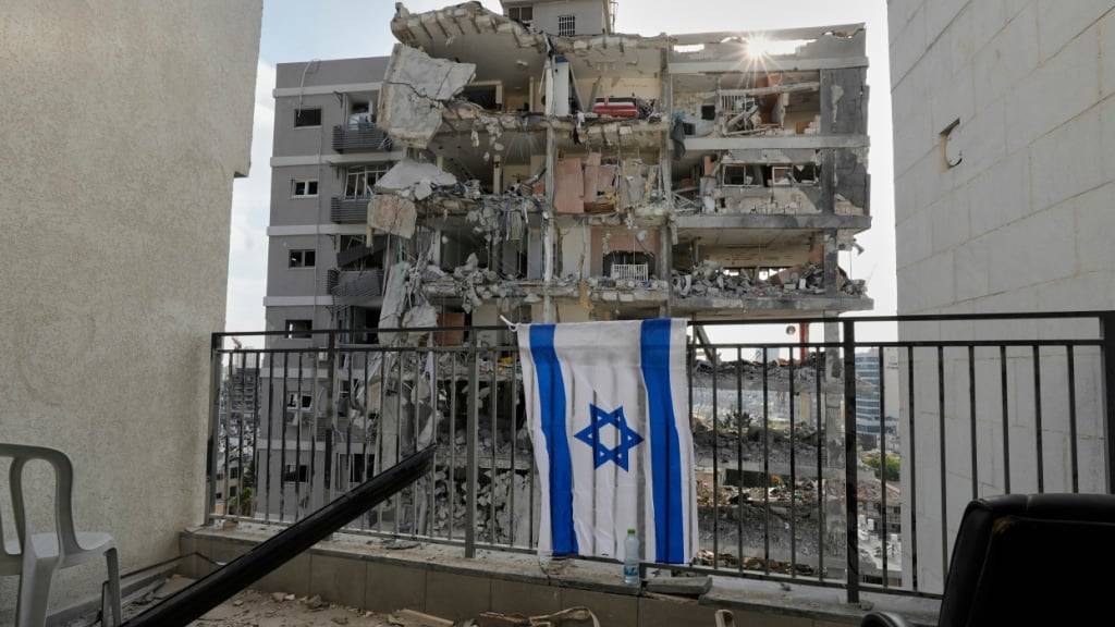 dpatopbilder - Eine israelische Flagge hängt am Balkongeländer eines der Wohnhäuser, die durch einen iranischen Raketenangriff zerstört wurden. Foto: Baz Ratner/AP/dpa
