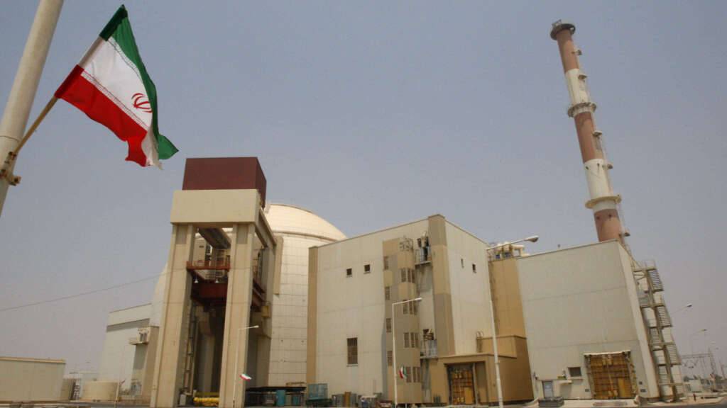 ARCHIV - Eine iranische Flagge flattert vor dem Reaktorgebäude des Kernkraftwerks Buscher. Foto: Vahid Salemi/AP/dpa