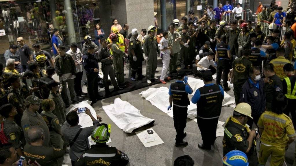 Abgedeckte Leichen liegen vor der Siam Commercial Bank (SCB) in Bangkok: Acht Arbeiter sind im Keller des Hauptsitzes erstickt.