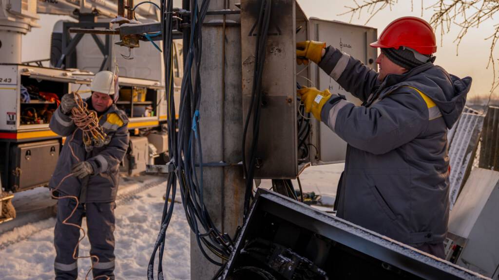 dpatopbilder - Elektriker reparieren einen Strommast, nachdem ein Transformator infolge eines Spannungsstoßes durch russische Luftangriffe auf die Energieinfrastruktur in der Region Kiew beschädigt wurde. Foto: Dan Bashakov/AP/dpa