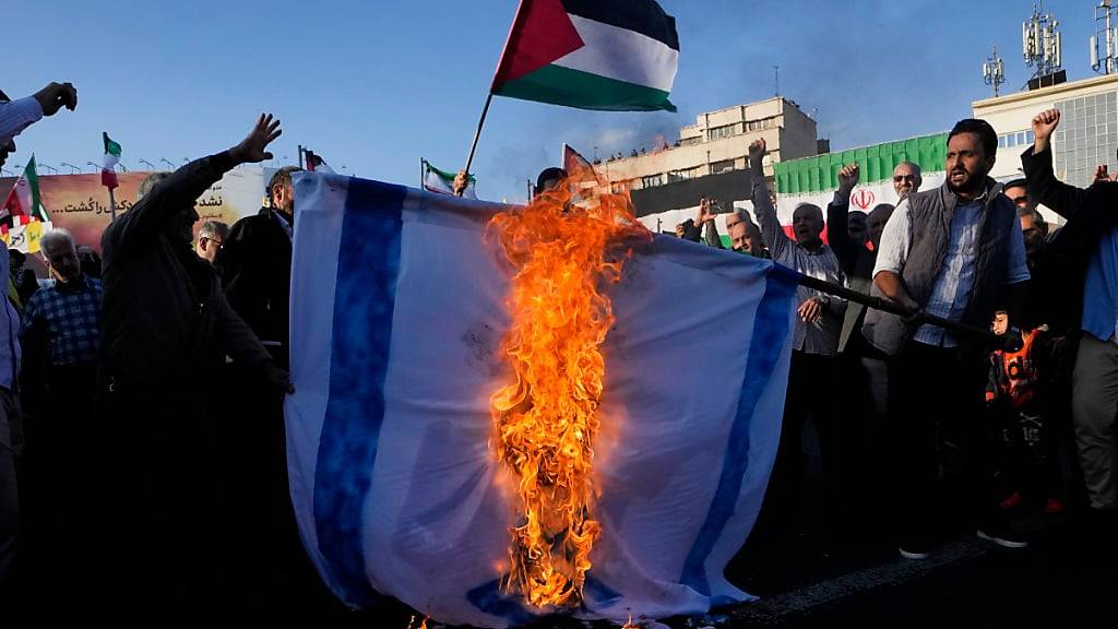 ARCHIV - Iranische Demonstranten verbrennen eine nachgestellte Israel-Flagge während einer propalästinensischen Kundgebung in Teheran. Foto: Vahid Salemi/AP/dpa