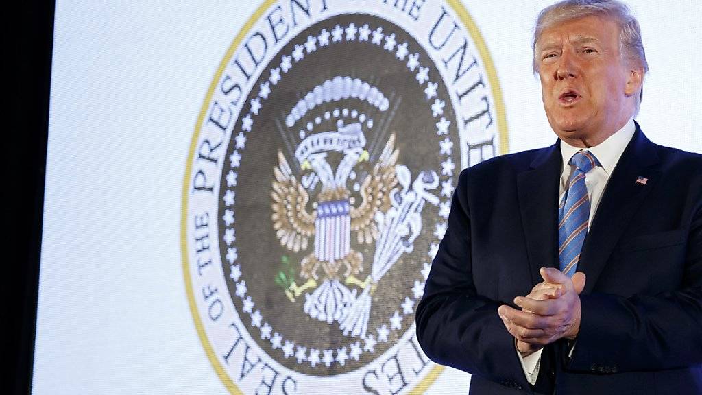 Doppelköpfiger Adler, Golfschläger und Geldscheine statt Pfeile und Zweig: US-Präsident Donald Trump vor dem gefälschten Präsidenten-Siegel an einer Studentenveranstaltung.
