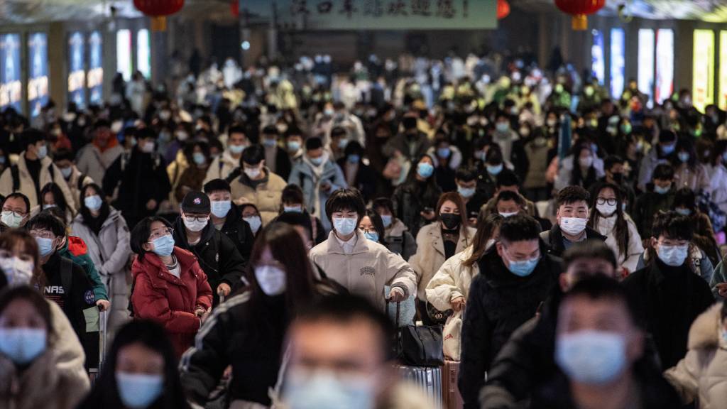 Passagiere kommen am Bahnhof Hankou in Wuhan an und tragen Mund-Nasen-Schutz. (Archiv)