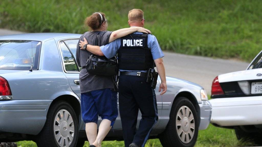 Nach dem Tod eines Polizisten in der US-Stadt Kansas City bringt ein Beamte eine Freundin der Opferfamilie zum Tatort.
