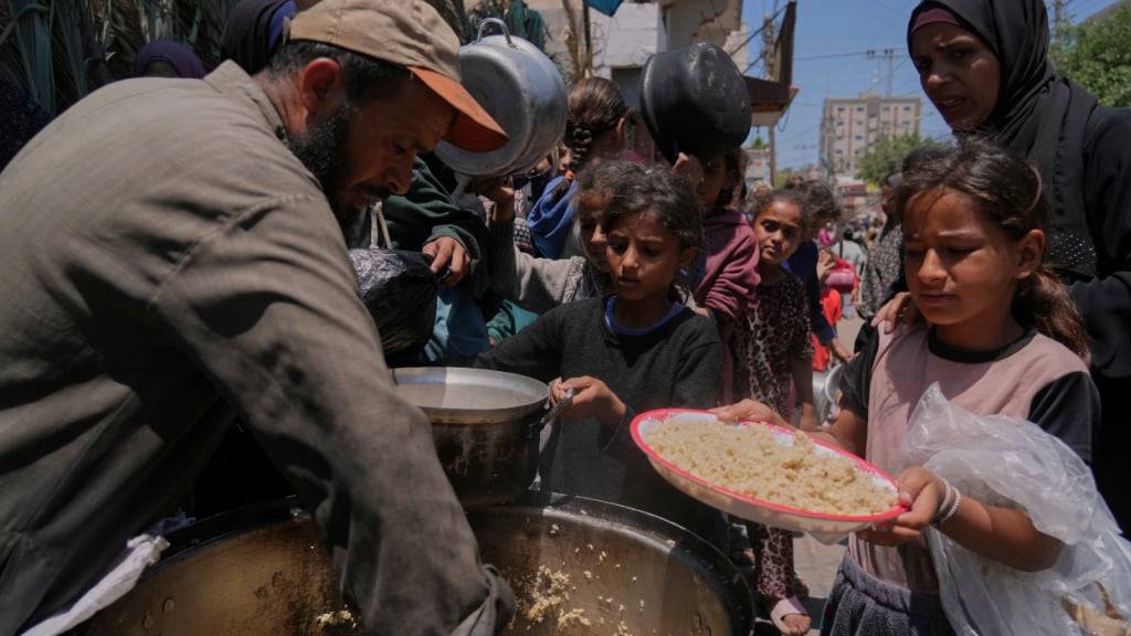 dpatopbilder - Palästinensische Kinder erhalten bei einer Lebensmittelverteilungsküche Essen. Foto: Abdel Kareem Hana/AP/dpa