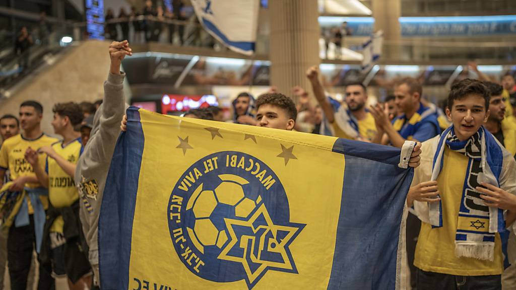 Fans von Maccabi Tel Aviv jubeln, als sie mit einem Flugzeug aus Amsterdam am Flughafen Ben Gurion ankommen. Foto: Ilia Yefimovich/dpa