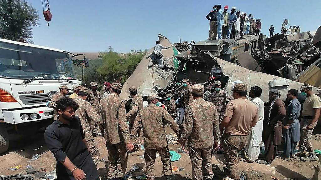 Truppen der pakistanischen Armee und Rettungskräfte sind am Ort der Zugkollision im Einsatz.