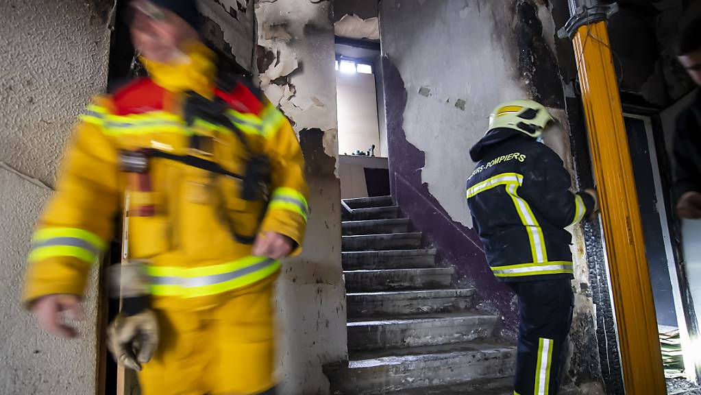 Feuerwehrleute an der Arbeit im vom Brand beschädigten Wohnblock in Genf.