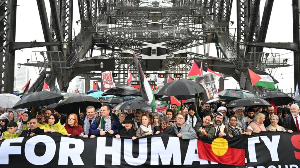Demonstranten überqueren die Sydney Harbour Bridge während des Marsches für Menschlichkeit der Palästina-Aktionsgruppe in Sydney, unter ihnen ist WikiLeaks-Gründer Julian Assange (r) zu sehen. Foto: Dean Lewins/AAP/dpa