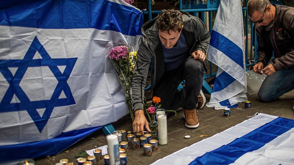 Trauernde zünden Kerzen an, während sie den Terroropfern am Ort eines Anschlags im Stadtzentrum gedenken. Nach einer Welle von Terroranschlägen, die in den vergangenen zwei Wochen 13 Menschen das Leben gekostet haben, herrscht in Israel höchste Alarmbereitschaft. Foto: Ilia Yefimovich/dpa