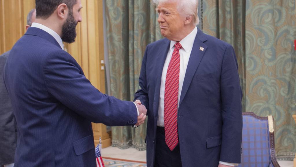 HANDOUT - US-Präsident Donald Trump (r) schüttelt dem syrischen Interimspräsidenten Ahmad al-Scharaa die Hand. Foto: Bandar Aljaloud/Saudi Royal Palace/dpa/Archivbild