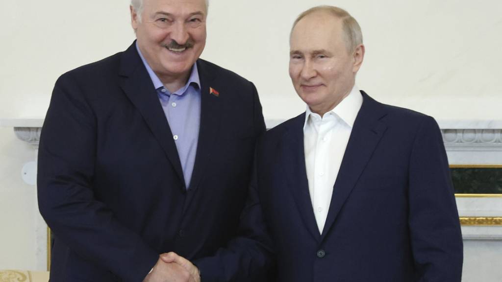 Wladimir Putin (r), Präsident von Russland, und Alexander Lukaschenko, Präsident von Belarus geben sich bei einem Treffen die Hand. Foto: Alexander Demianchuk/Pool Sputnik Kremlin/AP/dpa
