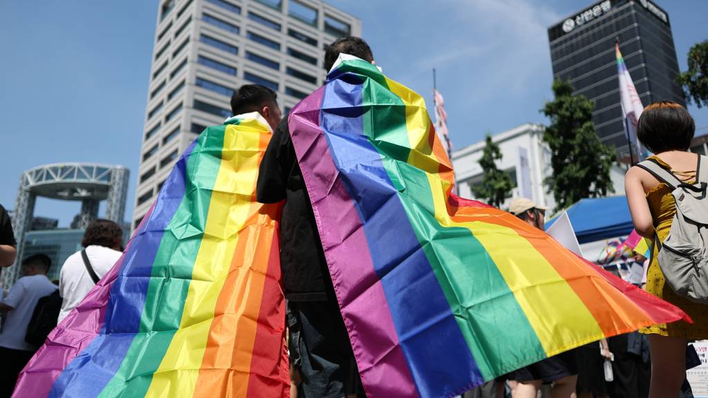 Teilnehmer des Seoul Queer Culture Festivals sind in Regenbogenfahnen gehüllt. Foto: -/YNA/dpa