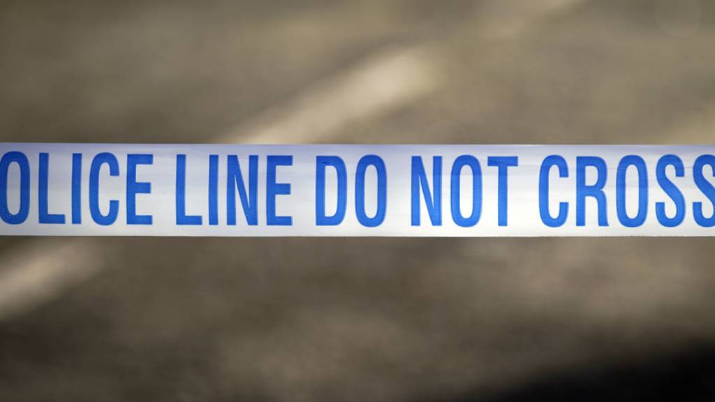 ARCHIV - Ein Absperrband der britischen Polizei, aufgenommen in der Nähe eines mutmaßlichen Tatortes. Foto: Peter Byrne/Press Association/dpa (Archivbild)